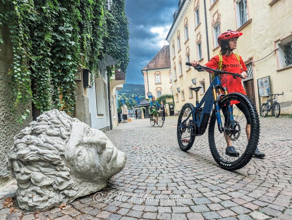 A cobbled road, with people on bikes passing by