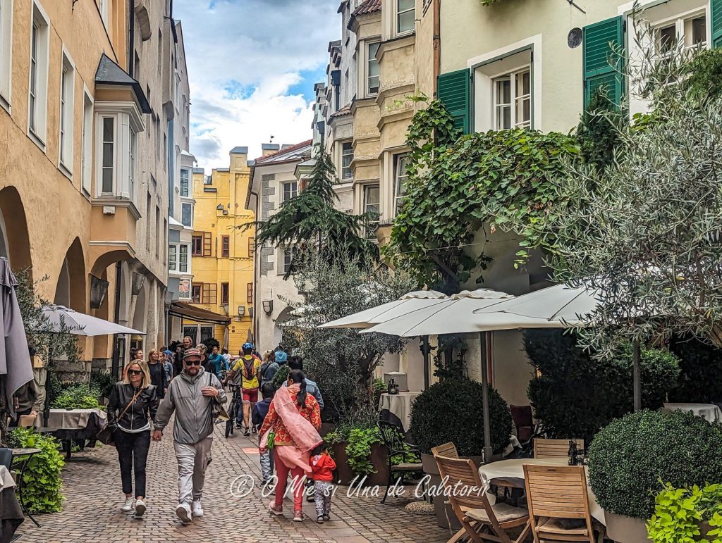 A street from the city, with old houses, people walking, small caffes