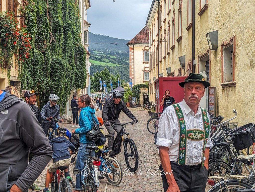 A person wearing a traditional costume surrounded by people in modern biking wear