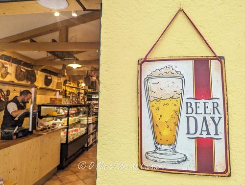 a metal poster saying "Beer Day" with the shop in the foreground