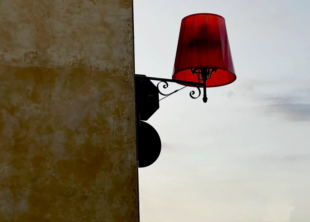 a red street lamp on a blue-grey sky