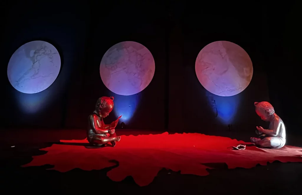 a work of art depicting two small persons on a red background