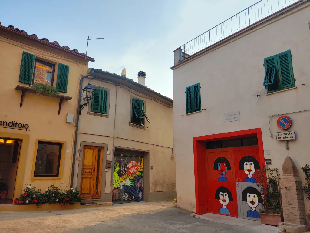 A street with coloured garage doors, filled with street art.