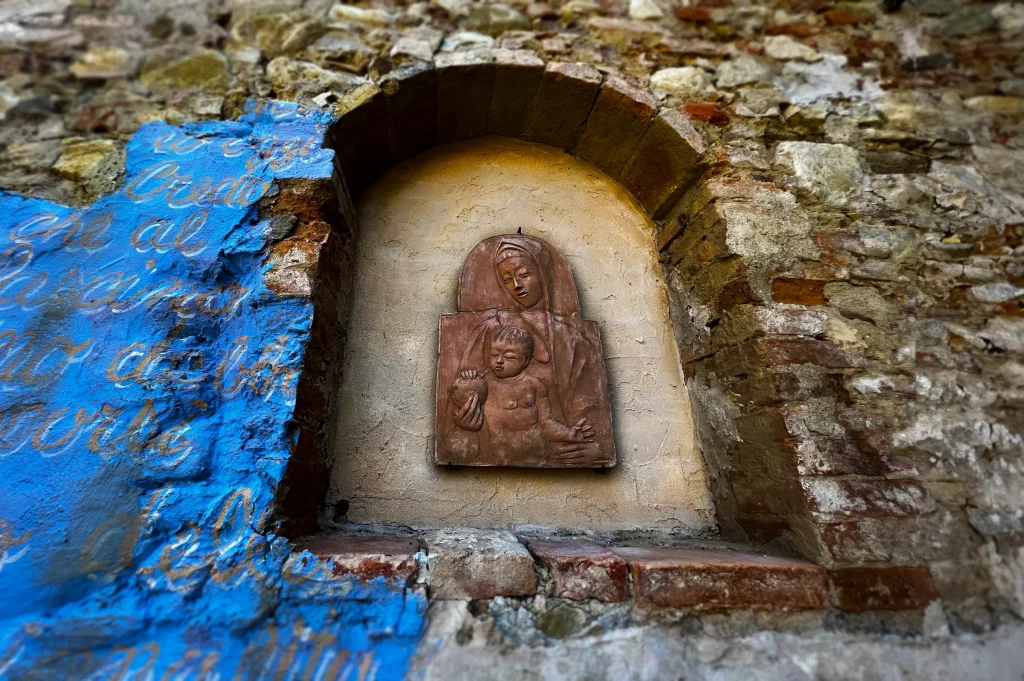 a close up of a piece of art inside a wall, depicting Mary and baby Jesus