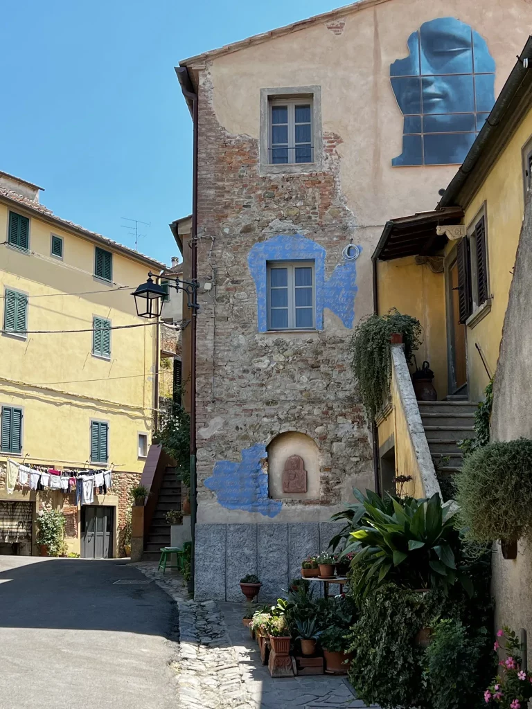a house with paint decorated windows and some street art on the upper area of the house