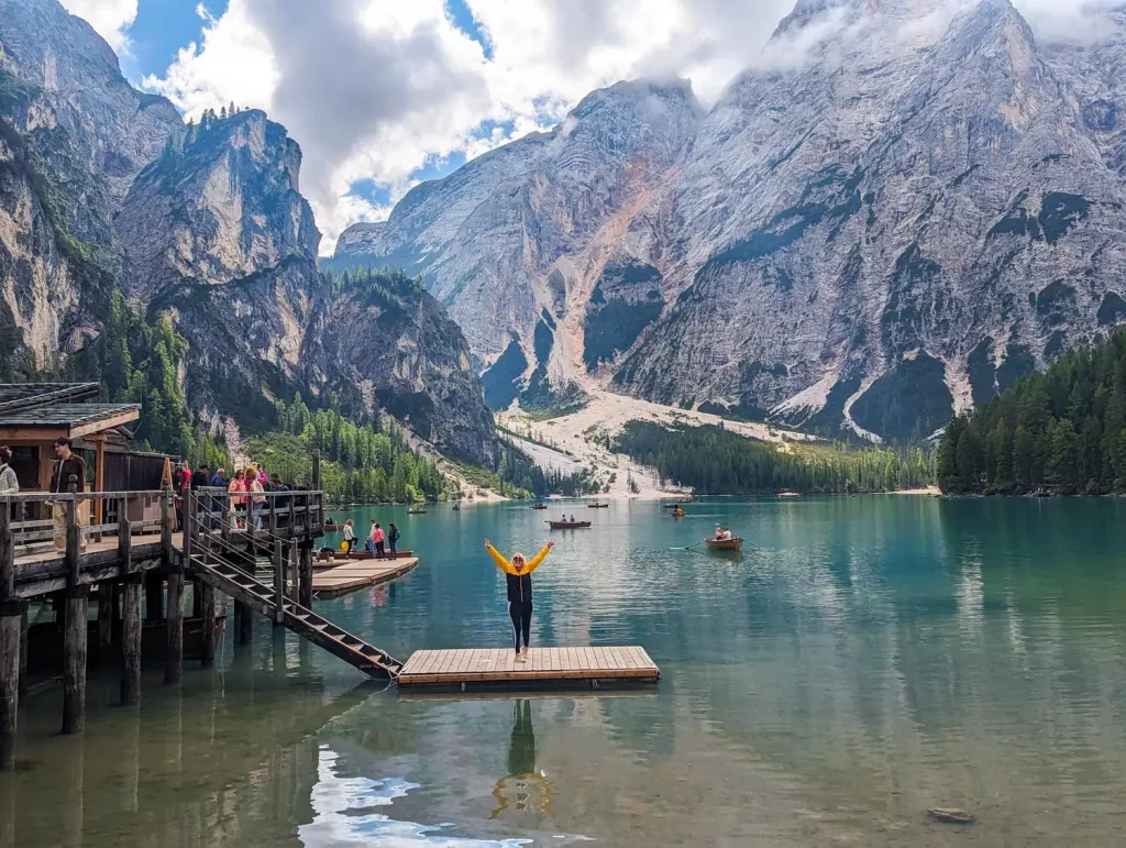 A wide shot of the Lago di Braies, with beautiful blue waters and massive mountains in the bacground