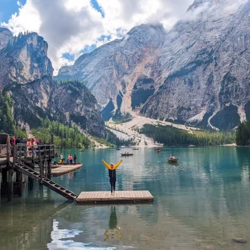 A wide shot of the Lago di Braies, with beautiful blue waters and massive mountains in the bacground
