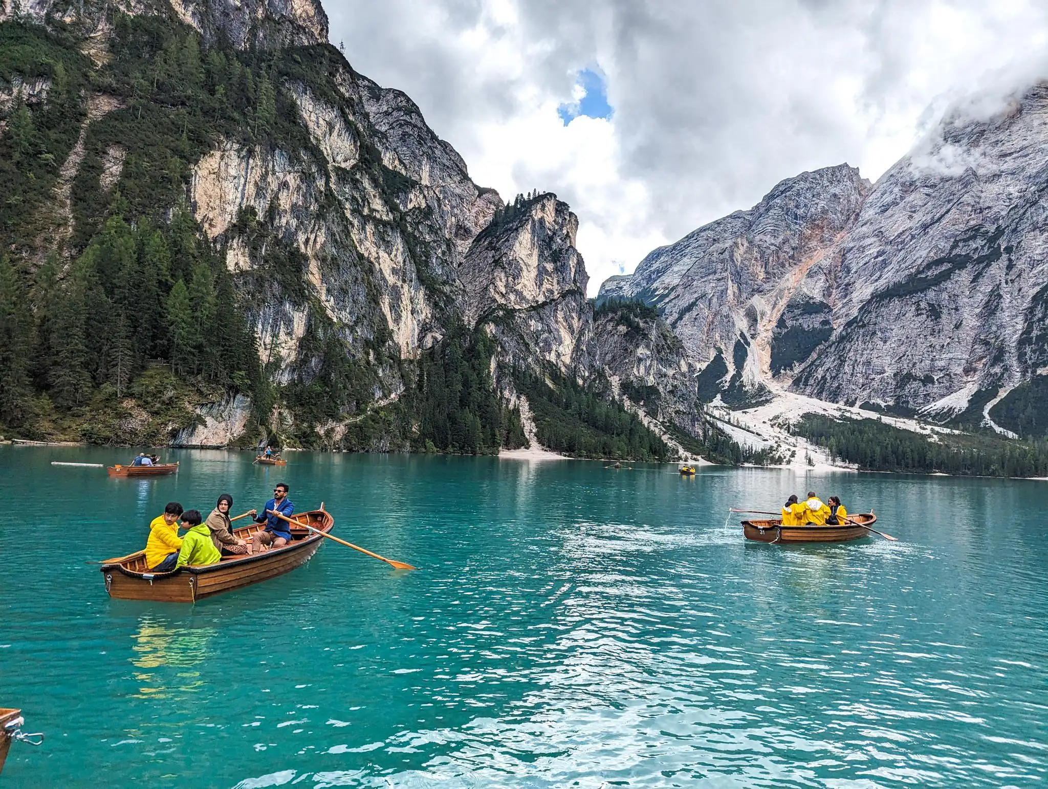 people rowing the rented boats, shot taken from the water, beautiful mountains in the background