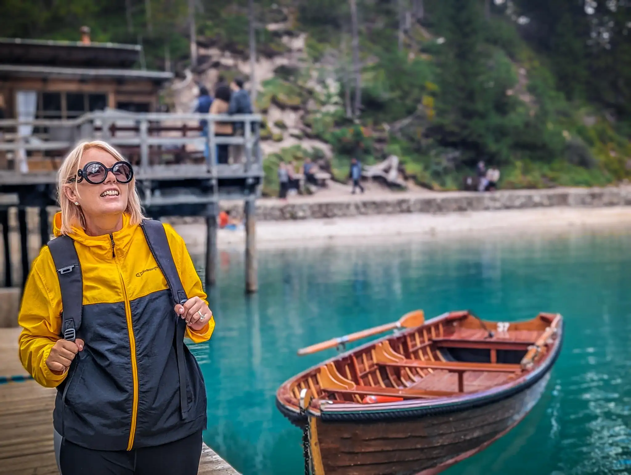 a portrait photo of the author with blurry of a boat and the lake.
