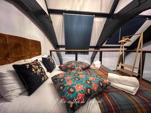 view of the bed in the main bedroom, with colourful pillows on the bed