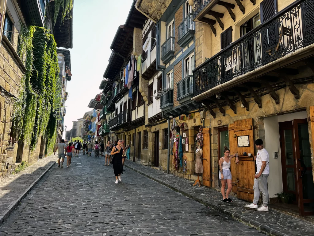 Cobbled street in a medieval city in Spain, with old houses and people walking