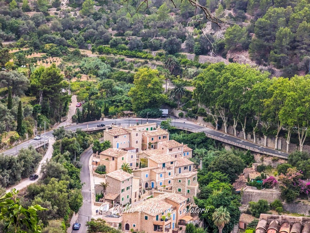A top view of some typical Mallorca houses more specifically, the town of Deia, with lush greenery and a highway