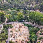 A top view of some typical Mallorca houses more specifically, the town of Deia, with lush greenery and a highway
