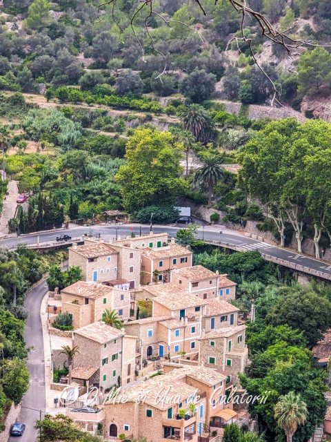 A top view of some typical Mallorca houses more specifically, the town of Deia, with lush greenery and a highway