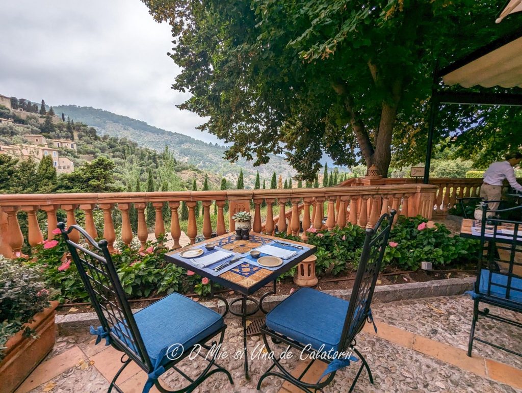 Another hill view from the terrace with a table with chairs in the foreground and houses and hill in the background