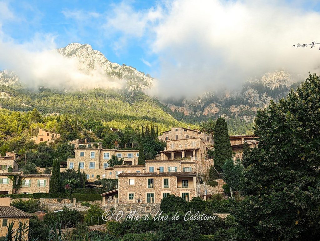 a wide view of some hill built houses, with mountains in the background