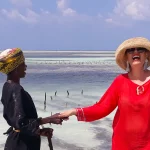 The worker from the farm holding hand with Alina and both laughing.