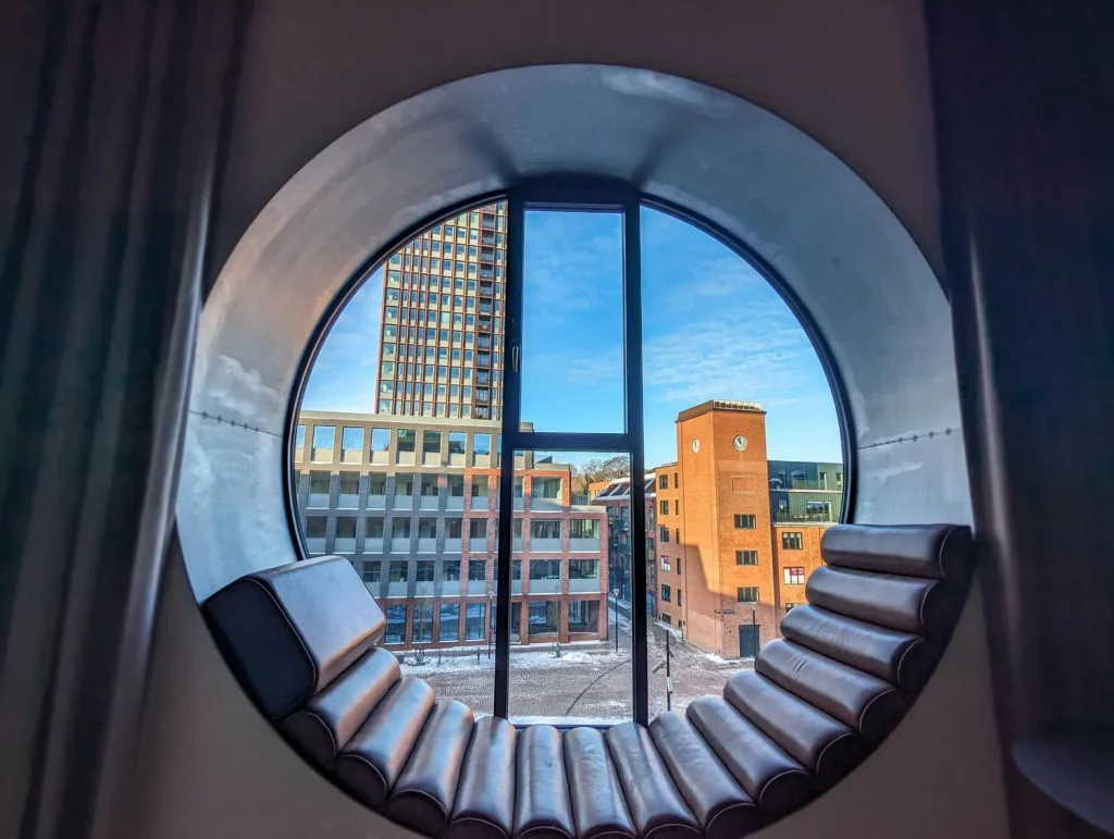 Denmark, shot outside the round window, with a modern sitting area inside the window frame.