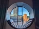 Denmark, shot outside the round window, with a modern sitting area inside the window frame.