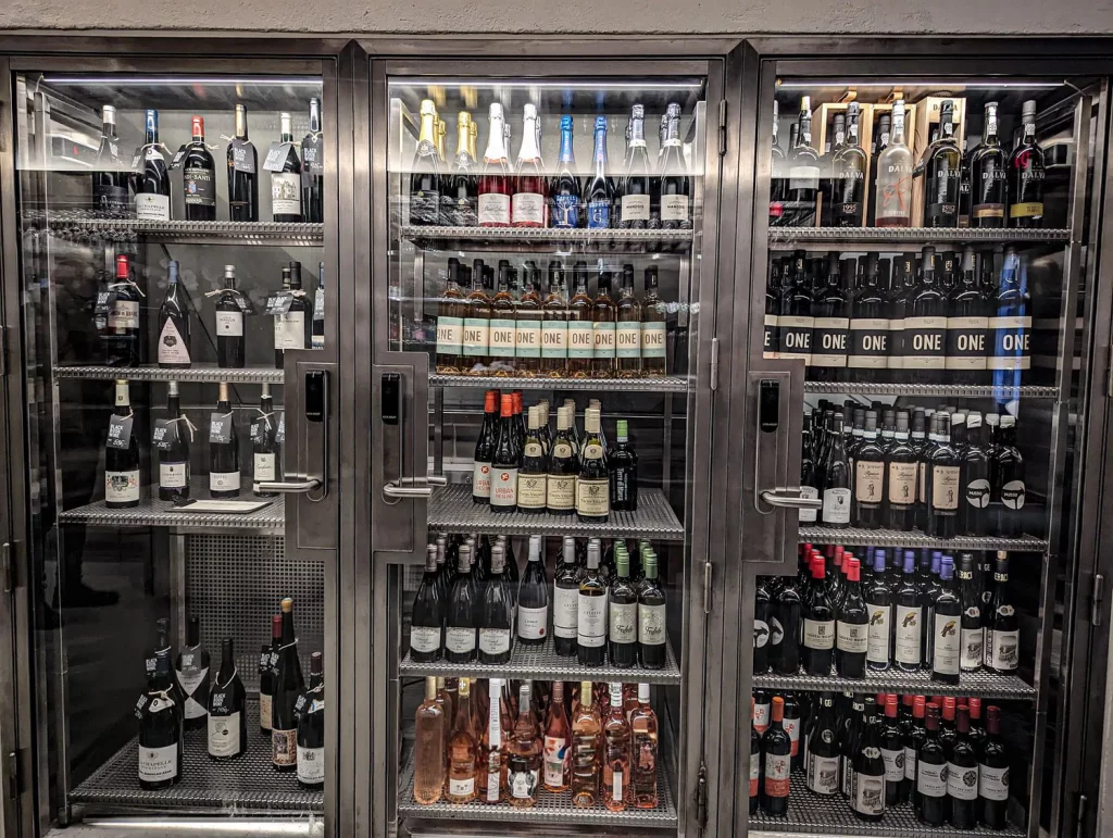 Denmark photo of a bar fridge full of various vine bottles.